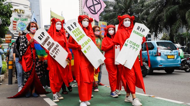 Massa dari berbagai komunitas saat menggelar aksi darurat iklim di Jalan Sudirman, Jakarta Pusat, Jumat (25/3/2022). [Suara.com/Alfian Winanto]