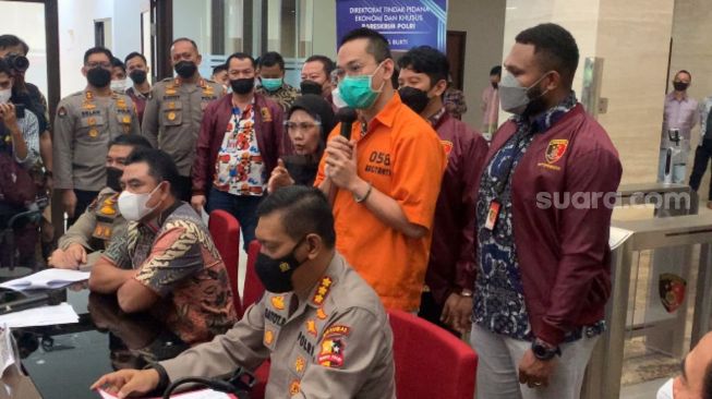 Tersangka Indra Kesuma alias Indra Kenz (tengah) dihadirkan saat rilis kasus dugaan penipuan berkedok trading binary option, Binomo di Bareskrim Mabes Polri, Jakarta Selatan, Jumat (25/3/2022). [Suara.com/Adiyoga Priyambodo]