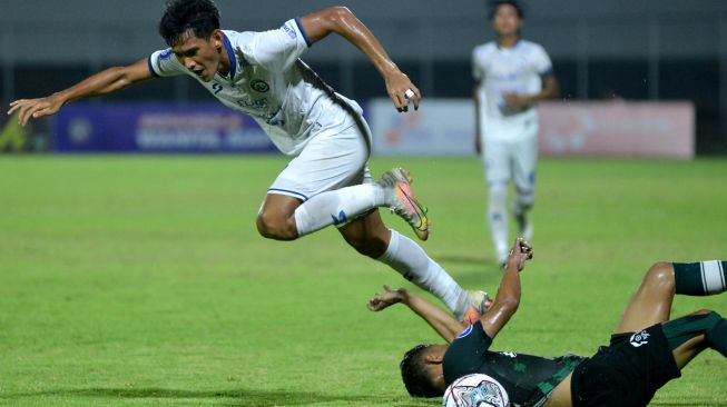 Pesepak bola Arema FC Ryan Kurnia (kiri) dihadang pesepak bola Persikabo 1973 Munadi (kanan) saat pertandingan Liga 1 di Stadion Kompyang Sujana, Denpasar, Bali, Kamis (24/3/2022). [ANTARA FOTO/Fikri Yusuf/hp]
