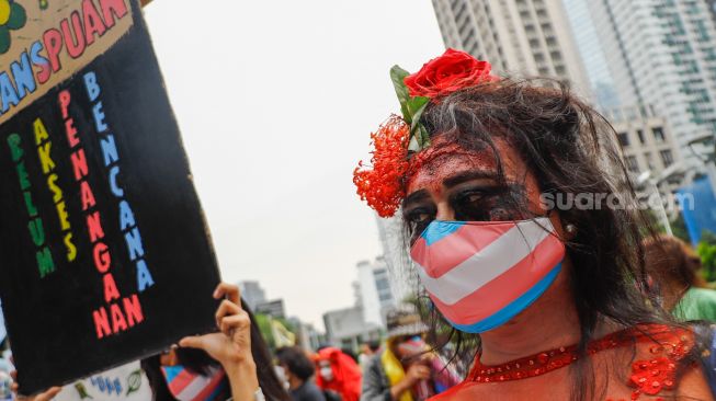 Seorang massa demonstrasi merias wajahnya saat mengikuti aksi darurat iklim di Jalan Sudirman, Jakarta Pusat, Jumat (25/3/2022). [Suara.com/Alfian Winanto]