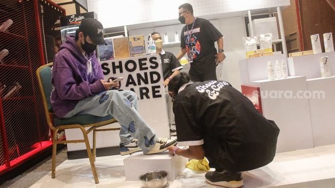 Pengunjung mencoba sepatu sneaker saat Event Jakarta Sneaker Day (JSD) di Mall Senayan City, Jakarta Pusat, Jumat (25/3/2022). [Suara.com/Septian]