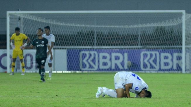 Pesepak bola Arema FC Rizky Dwi Febrianto melakukan sujud syukur usai mencetak gol ke gawang Persikabo 1973 saat pertandingan Liga 1 di Stadion Kompyang Sujana, Denpasar, Bali, Kamis (24/3/2022). [ANTARA FOTO/Fikri Yusuf/hp]