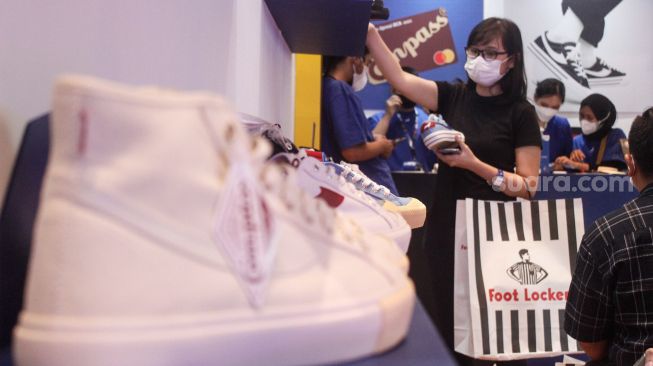 Pengunjung memilih koleksi sepatu sneaker saat Event Jakarta Sneaker Day (JSD) di Mall Senayan City, Jakarta Pusat, Jumat (25/3/2022). [Suara.com/Septian]