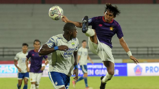 Pesepak bola Persib Bandung Bruno Cantanhede (kiri) berebut bola dengan pesepak bola Persik Kediri Yusuf (kanan) pada pertandingan Liga 1 di Stadion Kapten I Wayan Dipta, Gianyar, Bali, Jumat (25/3/2022). [ANTARA FOTO/Nyoman Hendra Wibowo/rwa]
