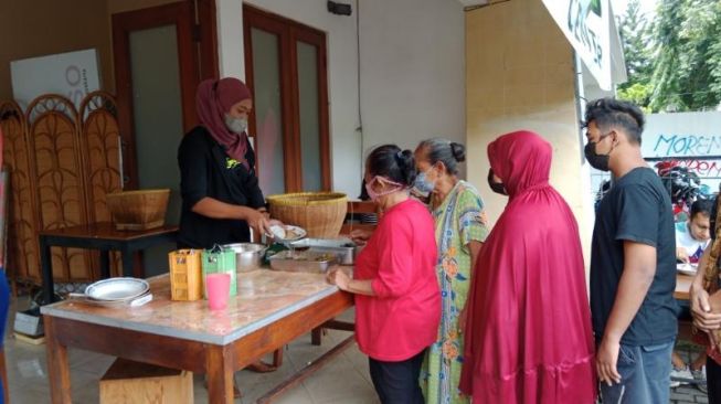 Sejumlah warga mengantri untuk menikmati sarapan di Warung Makan Gratis HTJRT, di Jalan Kenari, Umbulharjo, Kota Jogja, Jumat (25/3/2022). [Muhammad Ilham Baktora / SuaraJogja.id]