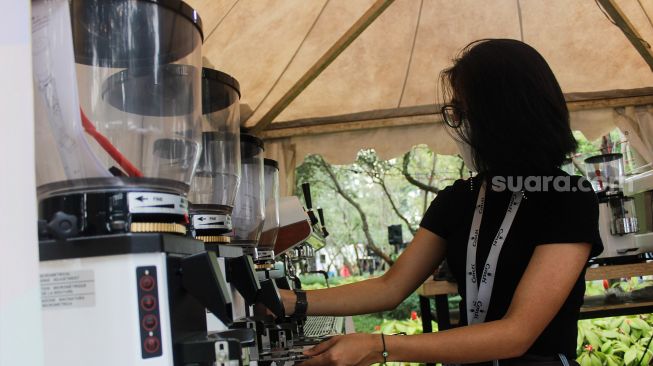 Pengunjung melihat-lihat berbagai jenis kopi saat Event Jakarta Coffee Experience 2022 di Grange Park Cipete, Jakarta Selatan, Jumat (25/3/2022). [Suara.com/Septian]