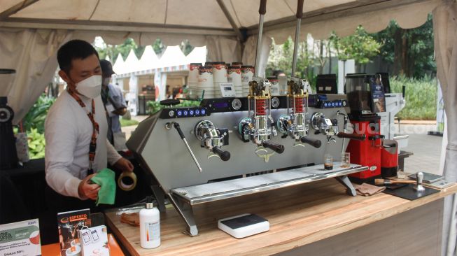 Pengunjung melihat-lihat berbagai jenis kopi saat Event Jakarta Coffee Experience 2022 di Grange Park Cipete, Jakarta Selatan, Jumat (25/3/2022). [Suara.com/Septian]