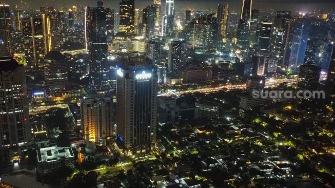 Suasana gedung-gedung bertingkat di Kawasan SCBD (Sudirman Central Business District) sebelum dipadamkan untuk memperingati Earth Hour di Jakarta, Sabtu (26/3/2022). [Suara.com/Alfian Winanto]