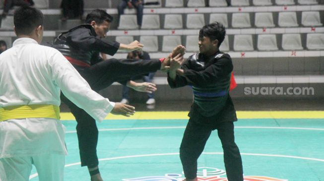 Pendekar silat Pagar Nusa saat bertanding dalam kejuaraan Nasional Keempat Sesi 2 Pagar Nusa di Padepokan Pencak Silat TMII, Jakarta, Minggu (27/3).   [Suara.com/Oke Atmaja]