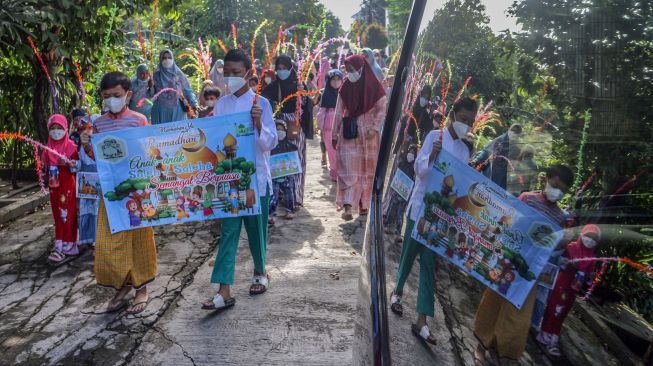 Sejumlah anak mengikuti pawai menyambut bulan Ramadhan di Jalan Pemancar Raya, Depok, Jawa Barat, Minggu (27/3/2022).  ANTARA FOTO/Yulius Satria Wijaya