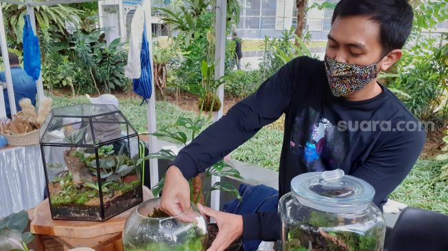 Suasana pengunjung piknik di halaman Kebun Raya Bogor, Bogor ,jawa Barat, Minggu (27/3/2022).  [Suara.com/Septian]