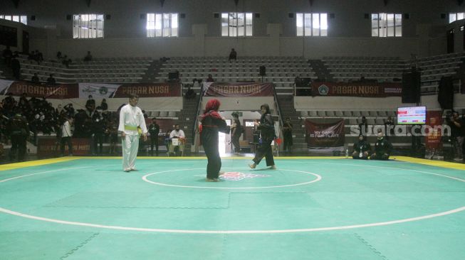 Pendekar silat Pagar Nusa saat bertanding dalam kejuaraan Nasional Keempat Sesi 2 Pagar Nusa di Padepokan Pencak Silat TMII, Jakarta, Minggu (27/3).   [Suara.com/Oke Atmaja]