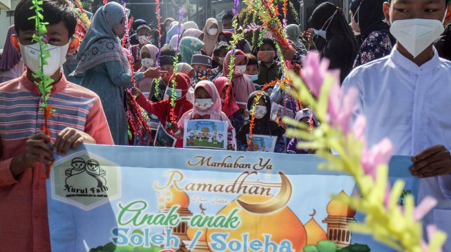 Sejumlah anak mengikuti pawai menyambut bulan Ramadhan di Jalan Pemancar Raya, Depok, Jawa Barat, Minggu (27/3/2022).  ANTARA FOTO/Yulius Satria Wijaya