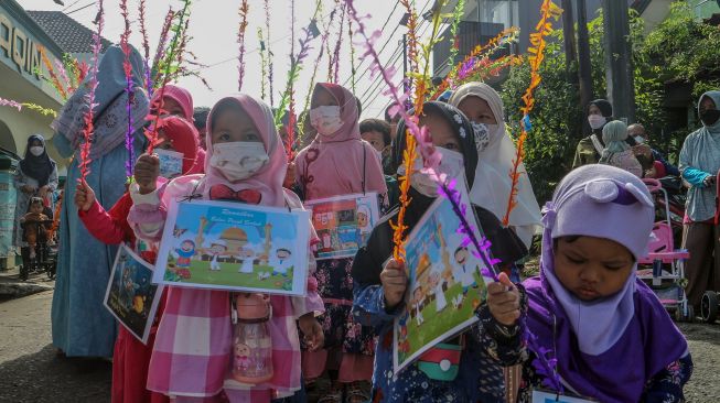 Sejumlah anak mengikuti pawai menyambut bulan Ramadhan di Jalan Pemancar Raya, Depok, Jawa Barat, Minggu (27/3/2022).  ANTARA FOTO/Yulius Satria Wijaya