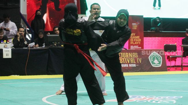 Pendekar silat Pagar Nusa saat bertanding dalam kejuaraan Nasional Keempat Sesi 2 Pagar Nusa di Padepokan Pencak Silat TMII, Jakarta, Minggu (27/3).   [Suara.com/Oke Atmaja]