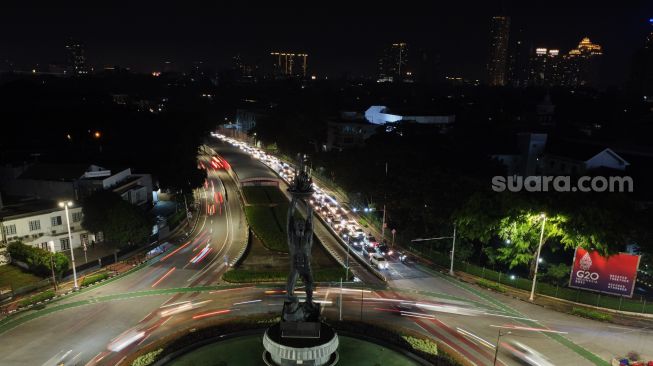 Lampu Patung Pemuda Membangun setelah dipadamkan untuk memperingati Earth Hour di Kawasan Senayan, Jakarta Selatan, Sabtu (26/3/2022). [Suara.com/Alfian Winanto]