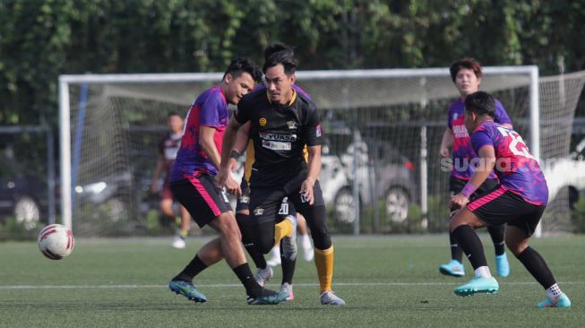 Pemain Selebritis FC Darius Sinathrya melewati lawan saat mengikuti sesi latihan di Lapangan ABC, Kompleks Gelora Bung Karno, Jakarta, Senin (28/3/2022). [Suara.com/Angga Budhiyanto]