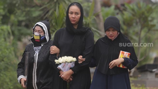 Kalina Oktarani menghantarkan sang ibunda Erlan Wardhania untuk dimakamkan di TPU Taman Abadi, Ciputat, Tangerang Selatan, Banten, Senin (28/3/2022). [Suara.com/Angga Budhiyanto]