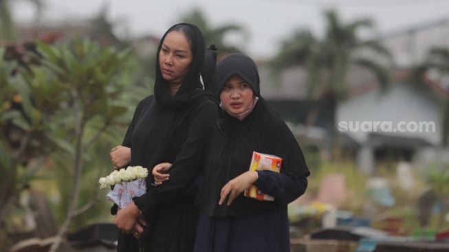 Kalina Oktarani menghantarkan sang ibunda Erlan Wardhania untuk dimakamkan di TPU Taman Abadi, Ciputat, Tangerang Selatan, Banten, Senin (28/3/2022). [Suara.com/Angga Budhiyanto]