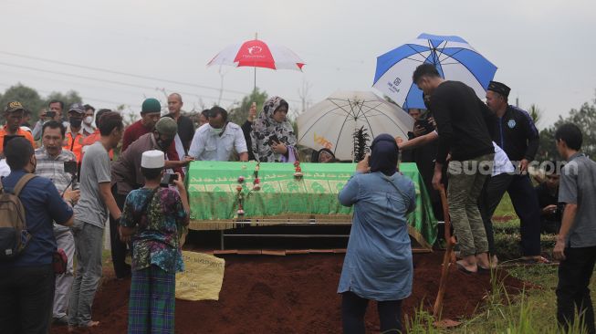 Keluarga dan kerabat memakamkan jenazah Ibunda Kalina Oktarani, Erlan Wardhania di TPU Taman Abadi, Ciputat, Tangerang Selatan, Banten, Senin (28/3/2022). [Suara.com/Angga Budhiyanto]