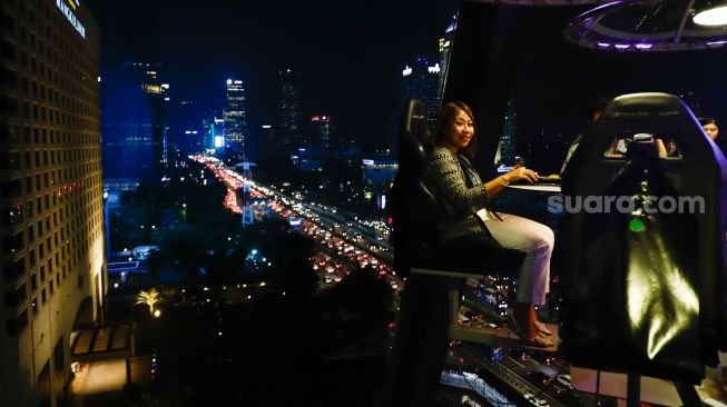 Pengunjung menikmati makan malam diatas ketinggian 50 meter di restoran Lounge In The Sky Indonesia di Setiabudi, Jakarta Selatan, Selasa (29/3/2022). [Suara.com/Alfian Winanto]