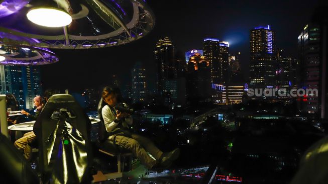 Pengunjung menikmati makan malam diatas ketinggian 50 meter di restoran Lounge In The Sky Indonesia di Setiabudi, Jakarta Selatan, Selasa (29/3/2022). [Suara.com/Alfian Winanto]