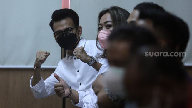 Terdakwa Adam Deni (kiri) bersiap mengikuti sidang dengan agenda pembacaan putusan sela kasus pelanggaran Undang-Undang ITE di Pengadilan Negeri Jakarta Utara, Jakarta, Selasa (29/3/2022). [Suara.com/Angga Budhiyanto]