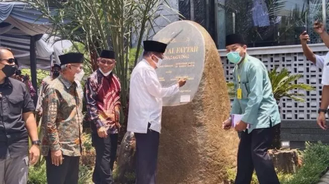 Ketua Umum Dewan Masjid Indonesia Jusuf Kalla menandatangani prasasti di depan Masjid Al Fattah yang disebut hemat energi dan ramah lingkungan, di Tulungagung, Jatim, Selasa (29/3/2022). [FOTO ANTARA/HO - Humas Pemkab Tulungagung]