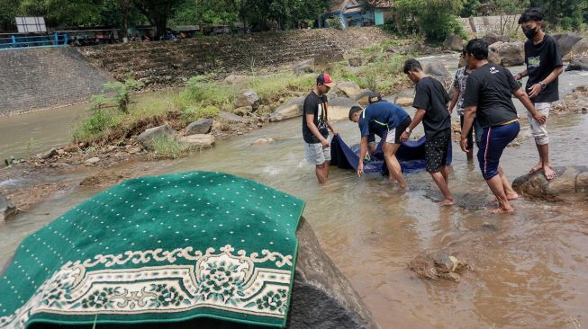 Warga mencuci karpet musala di Sungai Bendungan Kedungdowo Kramat, Kabupaten Batang, Jawa Tengah, Selasa (29/3/2022).  ANTARA FOTO/Harviyan Perdana Putra