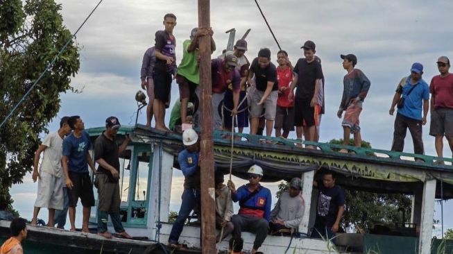 Viral! Aksi Gotong Royong Warga Desa Pela dan Sangkuliman Bantu PLN Dirikan Tiang Listrik Roboh Banjir Pujian Warganet