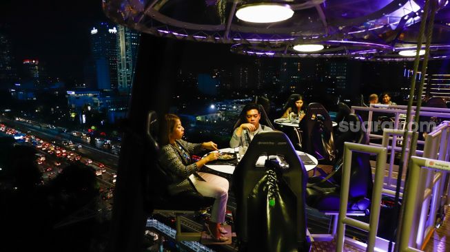 Pengunjung menikmati makan malam diatas ketinggian 50 meter di restoran Lounge In The Sky Indonesia di Setiabudi, Jakarta Selatan, Selasa (29/3/2022). [Suara.com/Alfian Winanto]