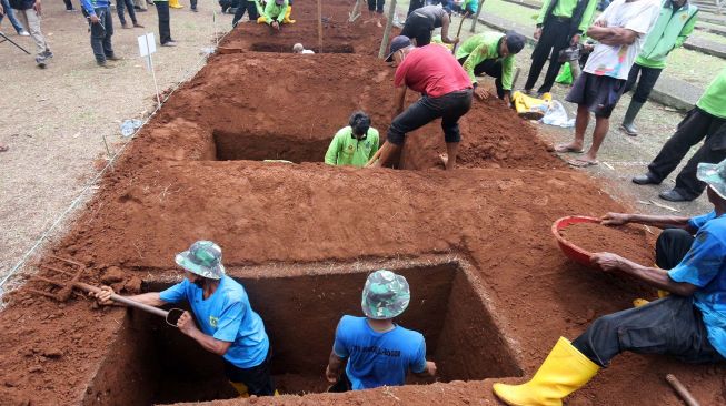 Petugas Tempat Pemakaman Umum (TPU) mengikuti lomba gali kubur di TPU Pondok Rajeg, Kabupaten Bogor, Jawa Barat, Selasa (29/3/2022). . ANTARA FOTO/Yulius Satria Wijaya
