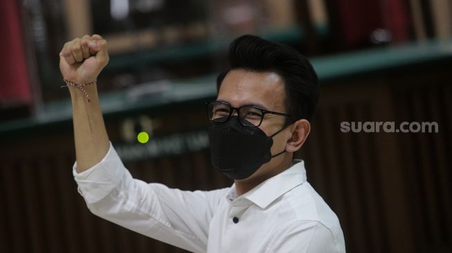 Terdakwa Adam Deni bersiap mengikuti sidang dengan agenda pembacaan putusan sela kasus pelanggaran Undang-Undang ITE di Pengadilan Negeri Jakarta Utara, Jakarta, Selasa (29/3/2022). [Suara.com/Angga Budhiyanto]