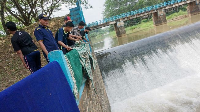 Warga menjemur karpet musala usai dicuci di Sungai Bendungan Kedungdowo Kramat, Kabupaten Batang, Jawa Tengah, Selasa (29/3/2022). ANTARA FOTO/Harviyan Perdana Putra
