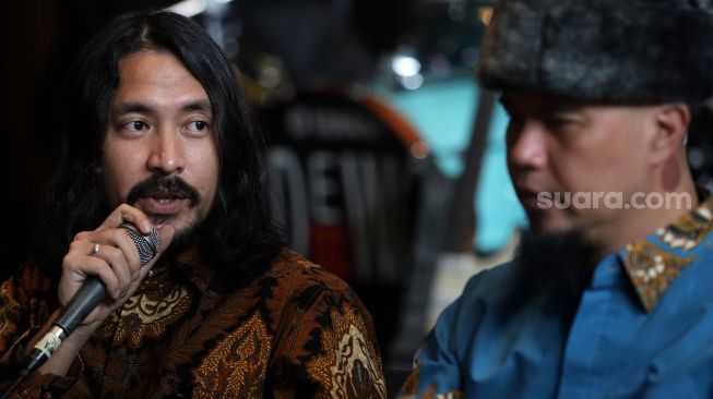 Penyanyi Marcello Tahitoe (kiri) memberikan keterangan pers saat acara perilisan lagu Dewa 19 "Juliette" di Holywings Kemang, Jakarta, Rabu (30/3/2022). [Suara.com/Angga Budhiyanto]