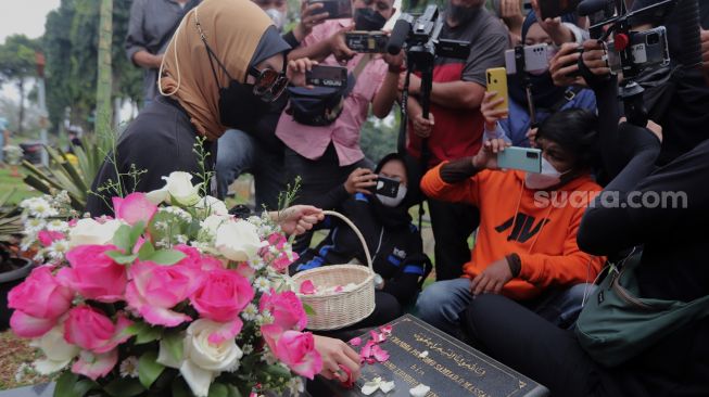 Mantan Politikus Angelina Sondakh berziarah ke makam suaminya, Adjie Massaid di TPU Jeruk Purut, Jakarta, Rabu (30/3/2022). [Suara.com/Angga Budhiyanto]