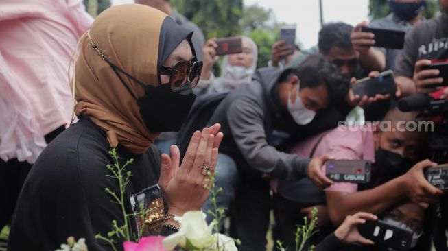 Mantan Politikus Angelina Sondakh berziarah ke makam suaminya, Adjie Massaid di TPU Jeruk Purut, Jakarta, Rabu (30/3/2022). [Suara.com/Angga Budhiyanto]