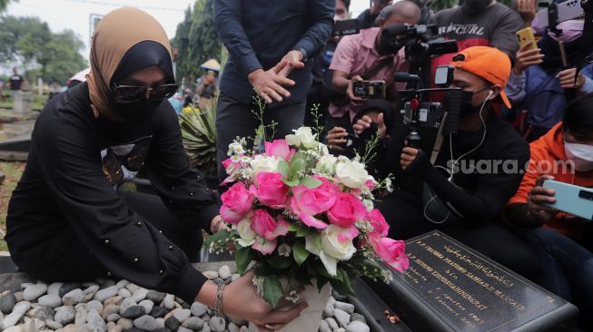 Mantan Politikus Angelina Sondakh berziarah ke makam suaminya, Adjie Massaid di TPU Jeruk Purut, Jakarta, Rabu (30/3/2022). [Suara.com/Angga Budhiyanto]