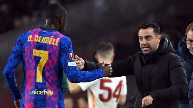 Ousmane Dembele mendengarkan arahan pelatih Xavi Hernandez ketika Barcelona menjamu Galatasaray di leg pertama babak 16 Liga Europa yang digelar di Camp Nou, 10 Maret 2022. [AFP]