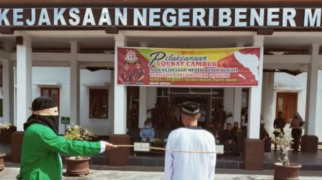 Seorang terpidana menjalani hukuman cambuk di halaman Kantor Kejaksaan Negeri Bener Meriah, Aceh, Selasa (29/3/2022). [Dok. Kejaksaan Negeri Bener Meriah]