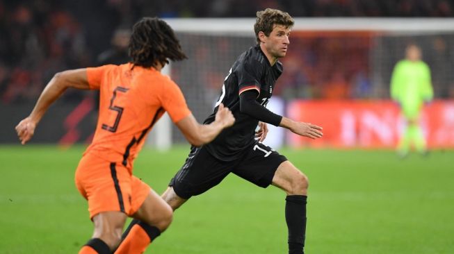 Penyerang Timnas Jerman, Thomas Muller (kanan) beraksi dalam laga persahabatan kontra Belanda di Johan Cruyff ArenA, Amsterdam, Belanda, Rabu (30/3/2022) dini hari WIB. [JOHN THYS / AFPOHN THYS / AFP]