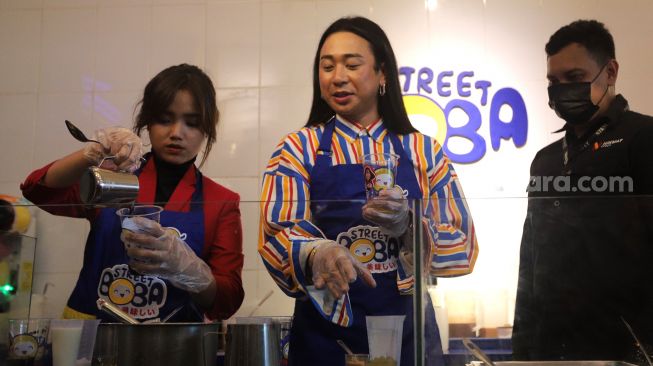 Fujianti Utami atau Fuji An (kiri) meracik minuman boba saat acara launching menu kolaborasi Fuji X Street Boba di Street Boba Ampera, Jakarta, Kamis (31/3/2022). [Suara.com/Angga Budhiyanto]