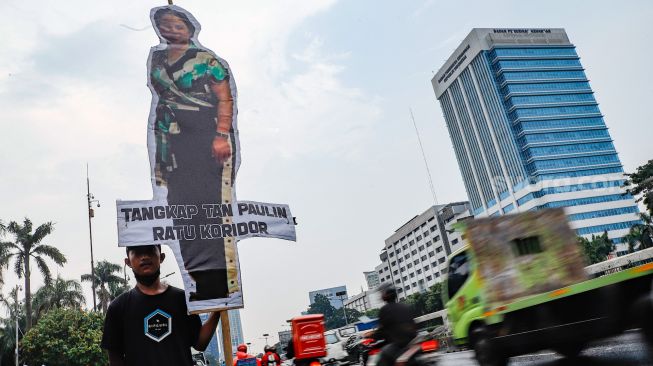 Massa membawa wayang besar bergambar Tan Paulin saat menggelar aksi demonstrasi di depan Gedung DPR RI, Jakarta Pusat, Kamis (31/3/2022). [Suara.com/Alfian Winanto]