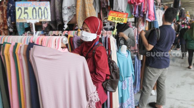 Warga berbelanja di Pasar Tanah Abang, Jakarta Pusat, Jumat (1/4/2022). [Suara.com/Alfian Winanto]