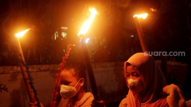 Sejumlah warga dan anak-anak mengikuti pawai obor di Jalan Menteng Jaya, Jakarta Pusat, Kamis (31/3/2022).  [Suara.com/Oke Atmaja]
