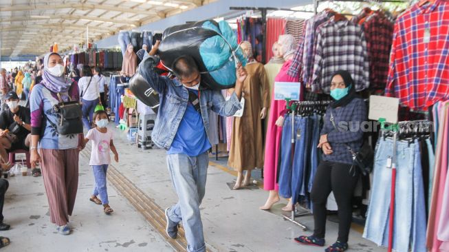 Warga berbelanja di Pasar Tanah Abang, Jakarta Pusat, Jumat (1/4/2022). [Suara.com/Alfian Winanto]