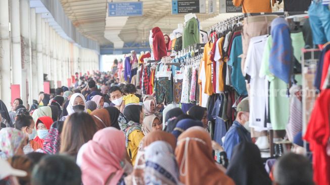 Warga berbelanja di Pasar Tanah Abang, Jakarta Pusat, Jumat (1/4/2022). [Suara.com/Alfian Winanto]