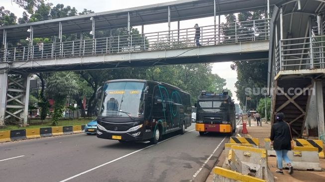 Penampakan kenderaan bus yang mengangkut polisi yang mengamankan demo mahasiswa tolak penundaan pemilu di kawasan Patung Kuda, Jakarta Pusat. (Suara.com/Yaumal)