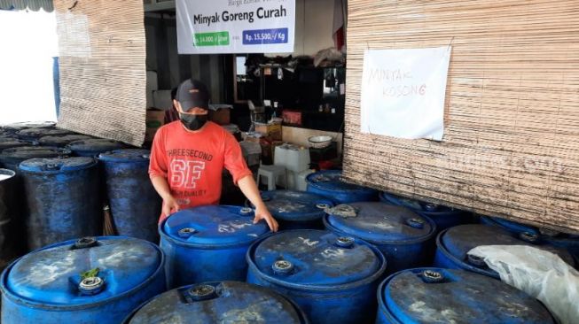 Pekerja menata drum minyak goreng di salah satu distributor, Jalan Bantul, Kelurahan Suryadiningratan, Kemantren Mantrijeron, Kota Jogja, Jumat (1/4/2022). - (SuaraJogja.id/Muhammad Ilham Baktora)