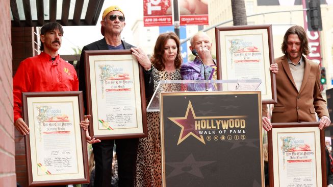 Para personil Band Red hot Chili Pepper Anthony Kiedis, Flea, John Frusciante and Chad Smith saat menghadiri acara peletakan emblem bintang Red Hot Chili Peppers di Hollywood Walk of Fame di Los Angeles, California, Amerika Serikat, Kamis (31/3/2022). [Michael Tran / AFP]